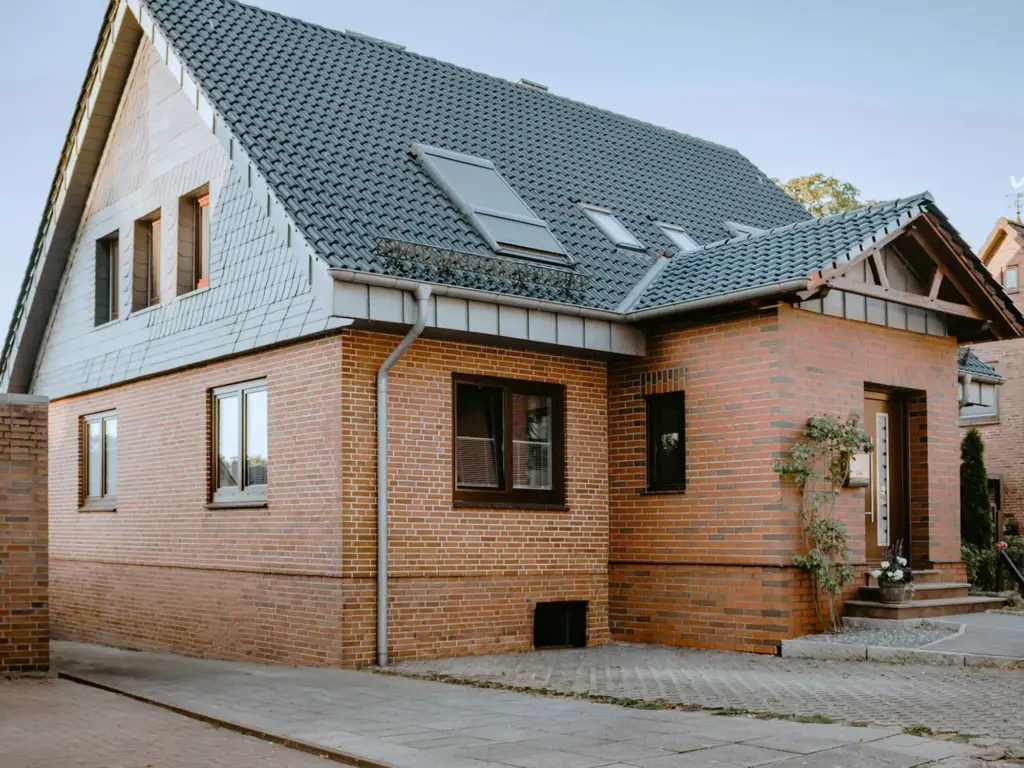 Immobilienverkauf: Aufnahme eines Hauses mit roten Klinkersteinen im Münsterland von außen