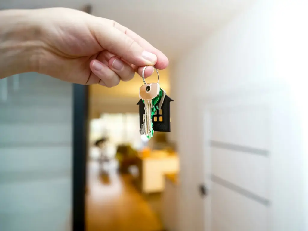 Immobilienvermietung im Münsterland: Hand die einen Schlüsselbund vor einem unscharfen Hintergrund hält